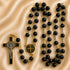 Black and gold Catholic rosary with a black and gold crucifix, and a round Saint Benedict medallion.