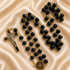 A black and gold rosary, a gold crucifix with black enamel, and a gold centerpiece medallion, on a satin fabric background.