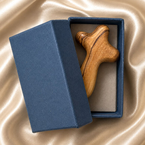 Olive wood comfort cross resting in an open blue gift box on ivory satin, ready as a Christian prayer or sympathy gift.