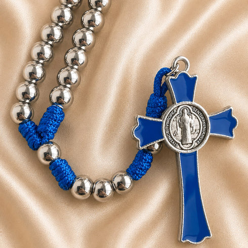 A rosary with silver beaded strands, bright blue knotted cord, and a blue cross pendant with a silver-tone medallion.