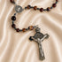 A rosary featuring amber marbled beads, silver-tone St Benedict medallion, and a detailed silver crucifix pendant.