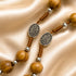 Olive wood rosary beads with Miraculous Medal markers on a folded satin beige cloth.