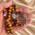 Hand holding a Saint Benedict olive wood rosary with Crown of Thorns crucifix