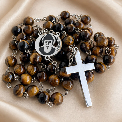 A Catholic rosary with brown tiger's eye beads, a silver-tone metal crucifix, and a round medallion