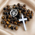 A Catholic rosary with brown tiger's eye beads, a silver-tone metal crucifix, and a round medallion