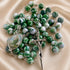 A green and white marbled bead rosary with a silver crucifix and an oval medallion.