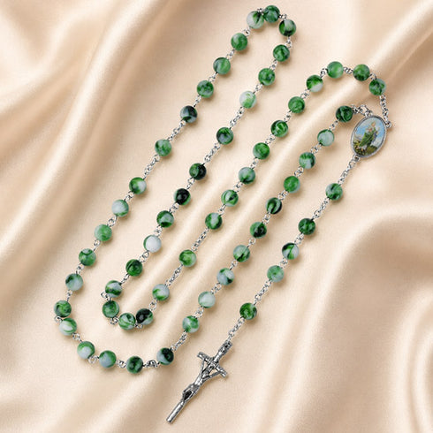 A green and white marbled beaded rosary with a silver crucifix and centerpiece medallion.