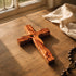 Wooden cross on a wooden surface with sunlight casting shadows