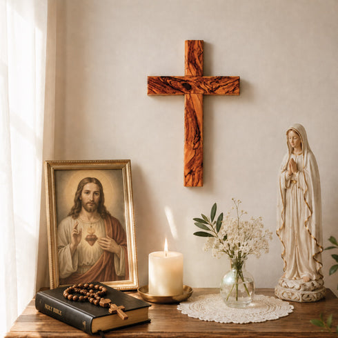 Religious decor with cross, statue, and candle on a table.