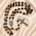 A Catholic rosary featuring brown and black tiger's eye beads, a silver-tone metal chain.
