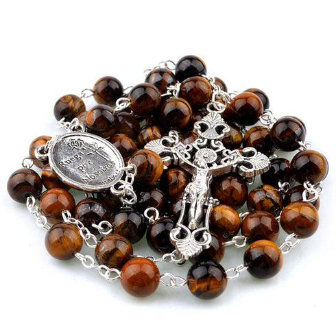 Brown beaded rosary with silver crucifix and medal on a white background