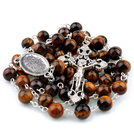 Brown beaded rosary with silver crucifix and medal on a white background