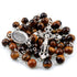 Brown beaded rosary with silver crucifix and medal on a white background