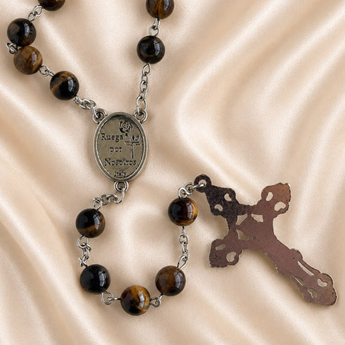 A Catholic rosary with polished brown and black tiger's eye beads, a silver-tone medallion, and a metal crucifix.