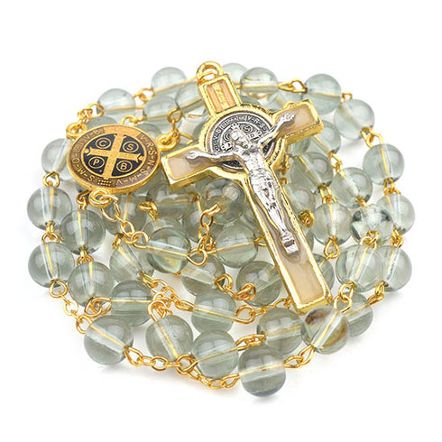 White glass beads rosary with gold chain and crucifix on a white background.