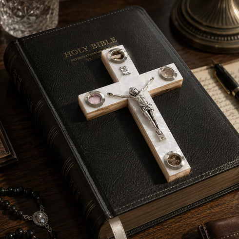 Decorative cross on a Holy Bible with a pen and paper in the background