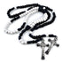 Black and white beaded rosary with silver cross on a white background