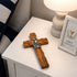 Olive wood communion cross for boys on a nightstand