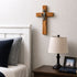 Wooden communion cross for boys on a wall next to bed and a lamp
