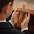 Boy holding a wooden communion cross in his hands