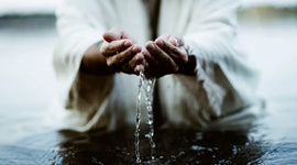 Jesus Christ's hands touching Jordan River water