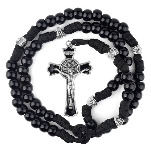 Men's rosary with black acrylic and silver Our Father beads, black crucifix and strong black cord, laid on white background.