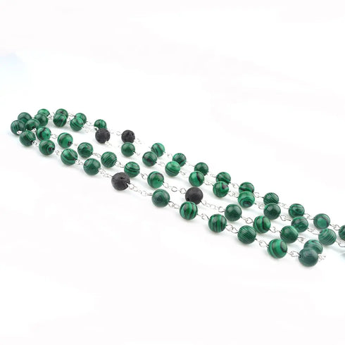 Holy Family Malachite rosary with lava stone accents, laid on white background.