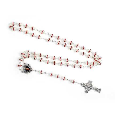 Immaculate Sacred Heart rosary with red rhinestone 8mm beads and silver Celtic crucifix, laid on white surface.