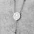 Silver Saint Benedict rosary with 4mm stainless steel beads and cross, laid on grey background.