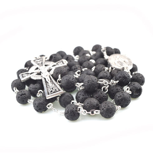 Black lava stone rosary with silver Celtic Crucifix and Miraculous medal on a white background