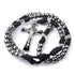 St. Benedict Rosary with silver steal beads and black cord on a white background.