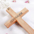 Handmade Catholic cross with "Jerusalem" written on the back, on white background with flowers around it.