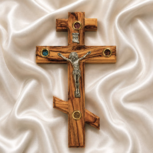 Orthodox wooden cross with Jesus Christ figure on a white fabric background