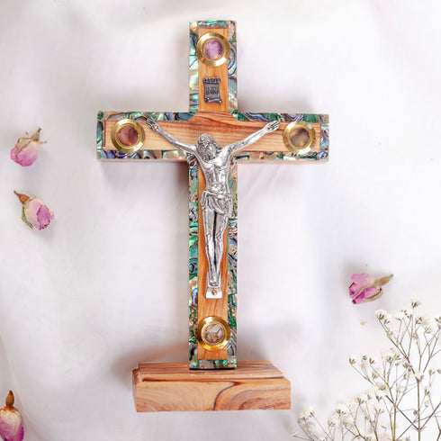 Small latin standing cross with crucifix, mother of pearl inlay and Four Elements, against white background.