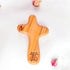 Olive wood comfort cross with the Piece of Holy Land logo, shown on white background with roses