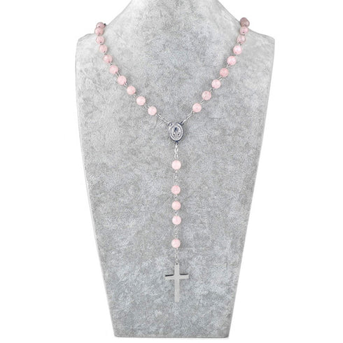 Pink beaded rosary necklace on a gray bust