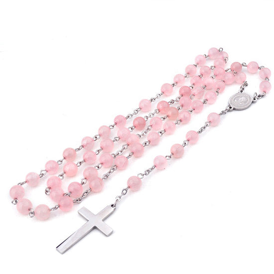 Pink rosary with silver cross on a white background