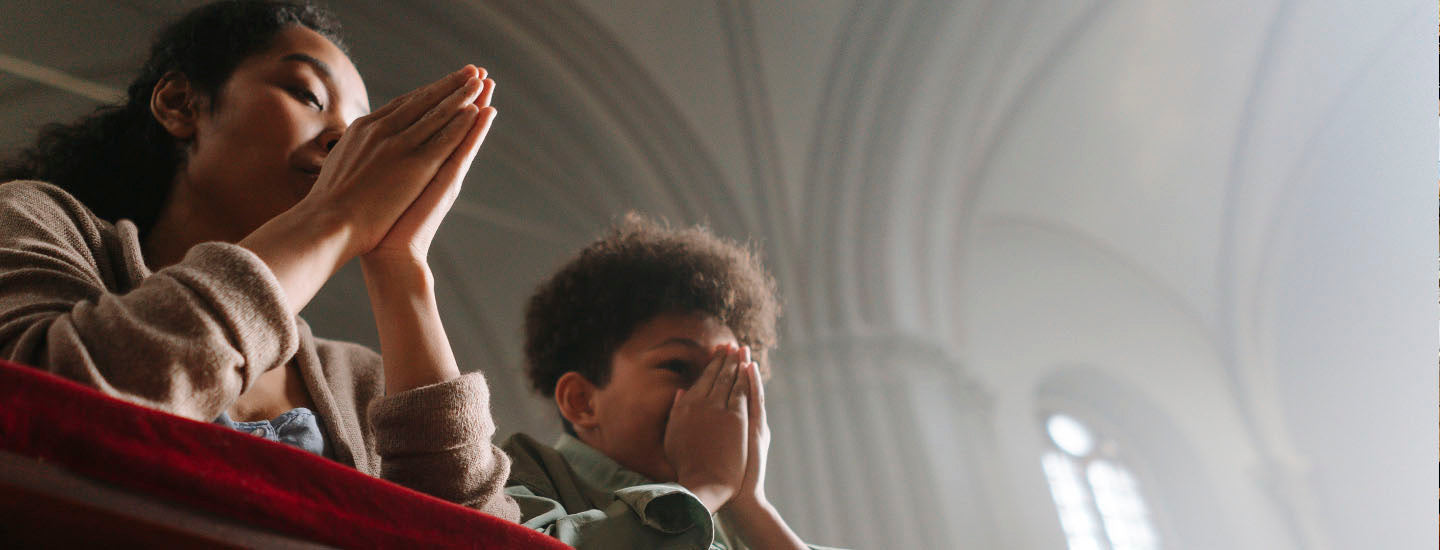 Mother and son praying in a church