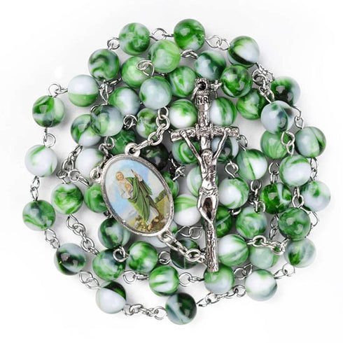 Green and white marbled rosary with silver crucifix on a white background